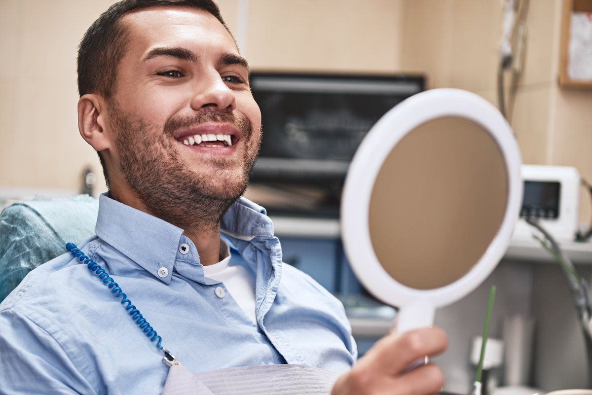 Smiling man holding a mirror